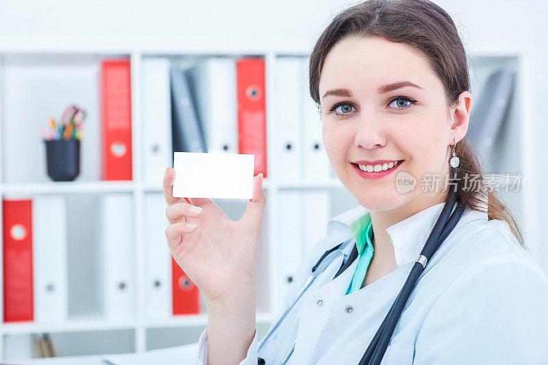 年轻的女医生展示一张空白的白色名片。