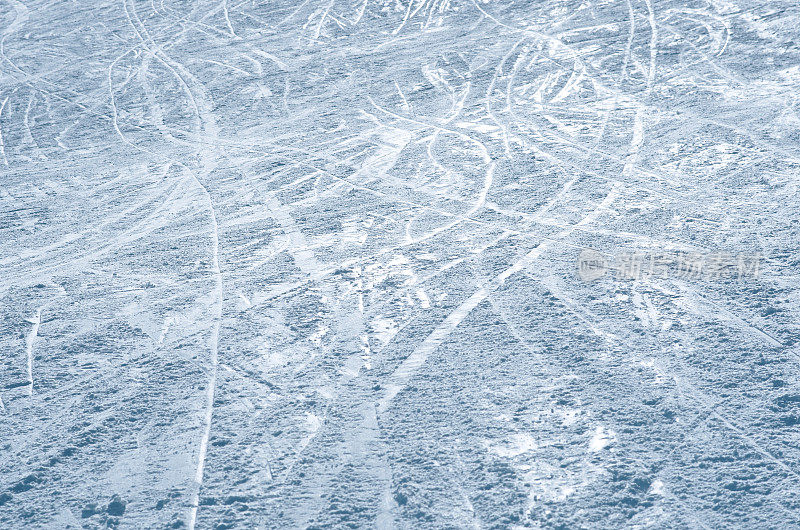 在阳光下有滑雪和滑雪板轨迹的斜坡