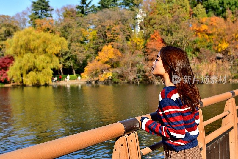 年轻的日本女人在桥上休息，在猪ashira公园，东京