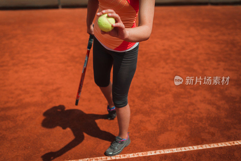一个网球运动员在红土球场发球的特写