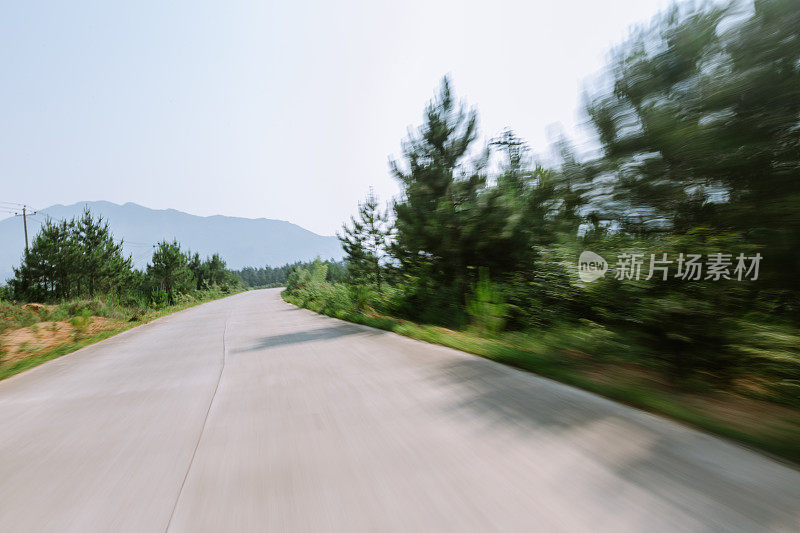 在阳光明媚的日子里，乡间小路上有绿油油的草地