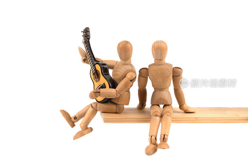 木制人体模型在给朋友弹吉他