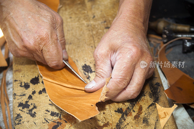 鞋匠的手制造皮靴和皮鞋。