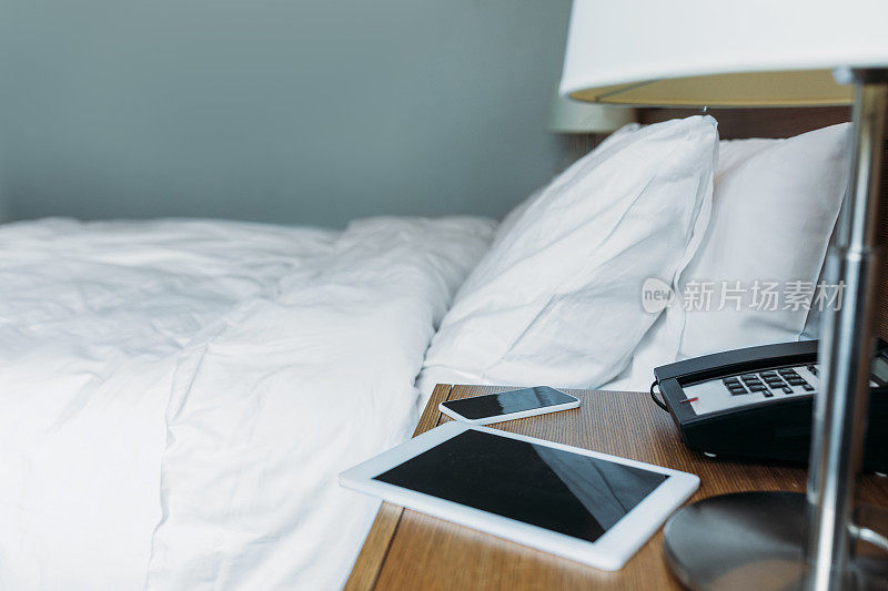酒店房间床头柜上放智能手机和平板电脑