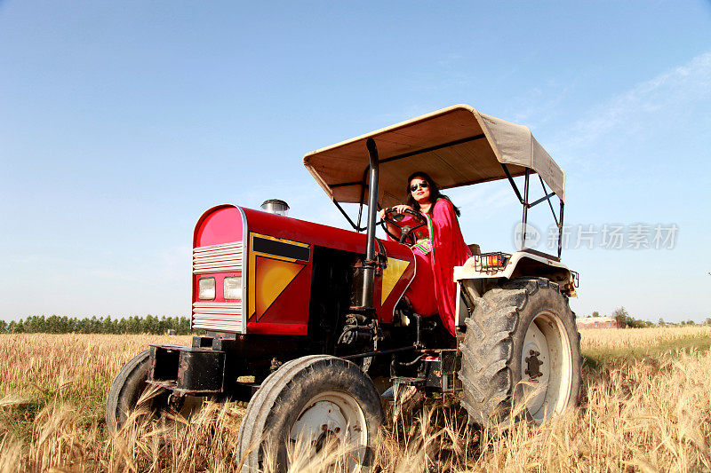 农妇开着一辆旧拖拉机穿过田野