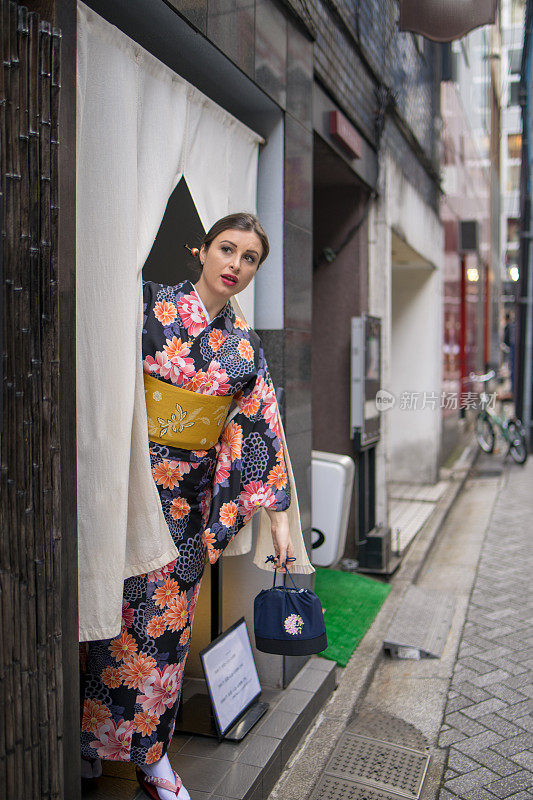 一位穿着和服的英国妇女正在找日本餐馆的服务员