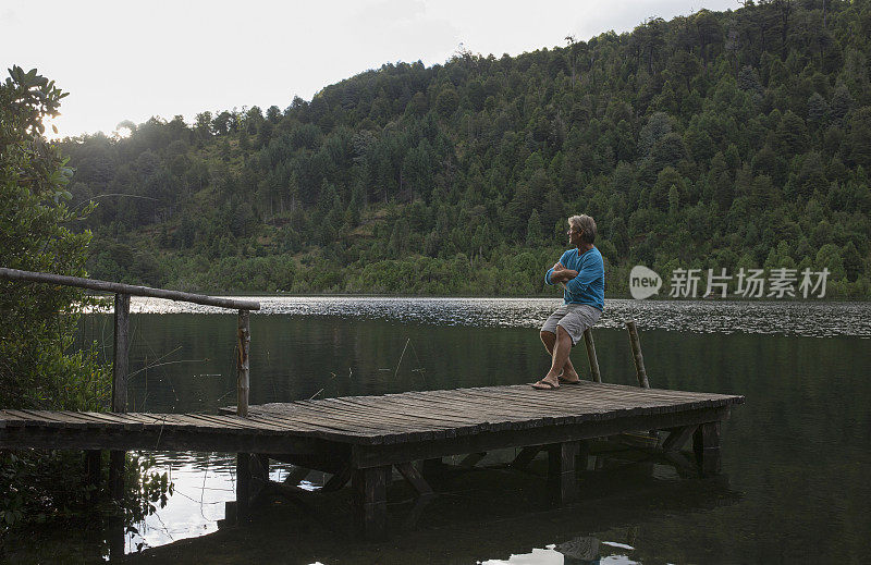 日出时分，男子在湖边码头休息