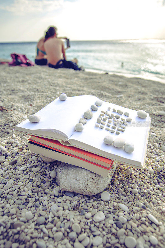 夏日阅读——在沙滩上看书，有人做背景
