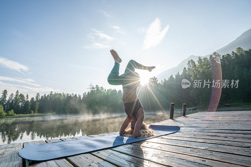 女人练习瑜伽姿势在自然，湖码头