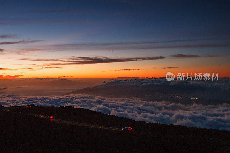 黄昏的哈雷阿卡拉火山口:哈雷阿卡拉公路，毛伊岛和城市灯光卡胡卢伊