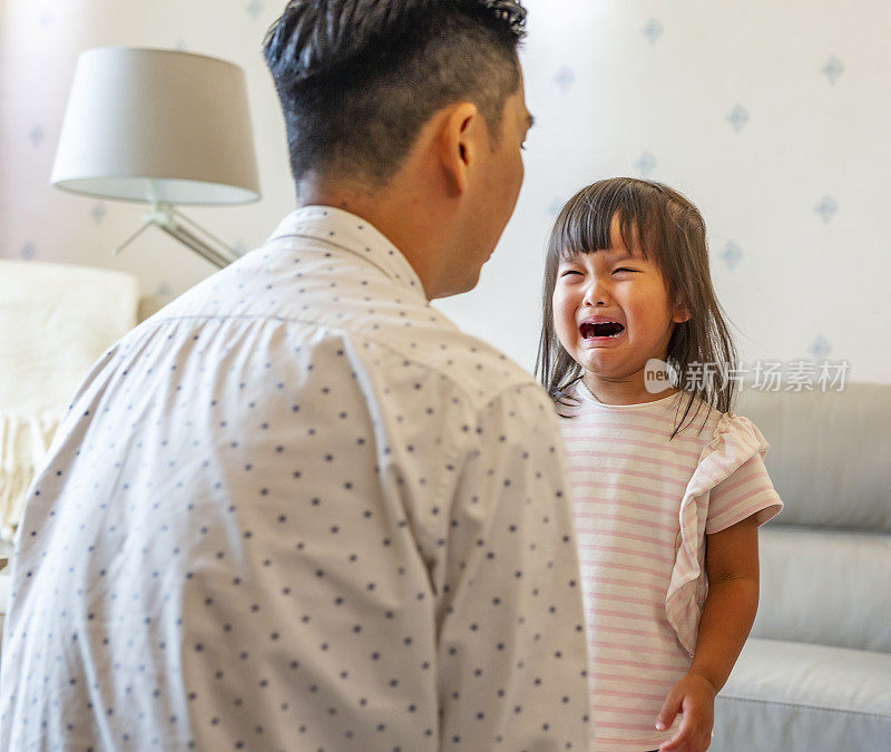 悲伤和哭泣的女儿被她的父亲安慰