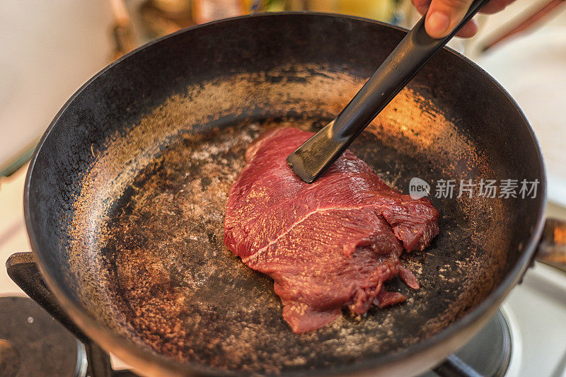 臀部牛排在平底锅里烤，特写