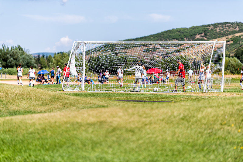 学校操场的运动在犹他州的滑雪度假小镇在夏天与人们踢足球