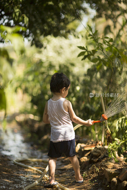 幼童在夏天在户外玩水管