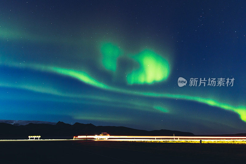 冰岛高速公路和山脉上方的北极光风景