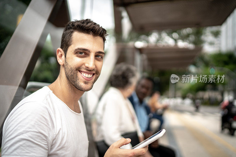 一个男人在公交车站使用手机的肖像