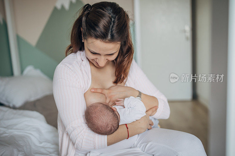 母亲在家里母乳喂养她的男婴