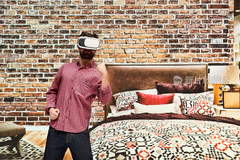 白种年轻男性在卧室里使用虚拟现实模拟器