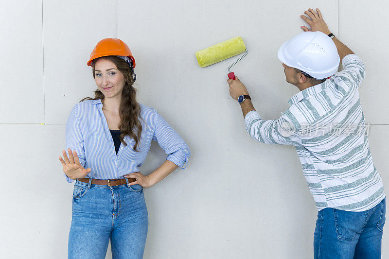 这对夫妇正在用石膏板装修他们的新家。干墙