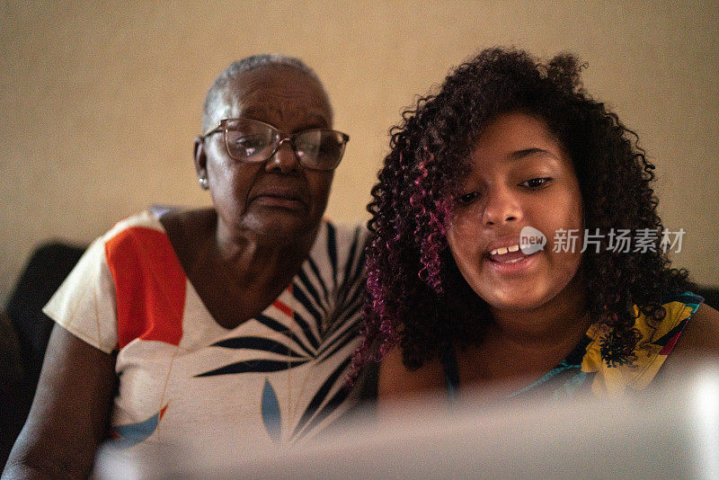 祖母和孙女正在用家里的平板电脑进行视频通话