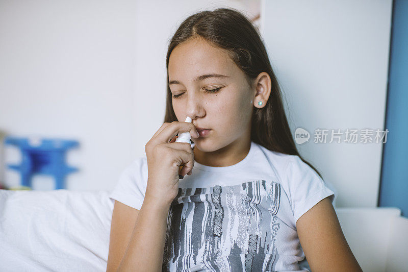 少女因感冒在卧室里使用鼻喷剂