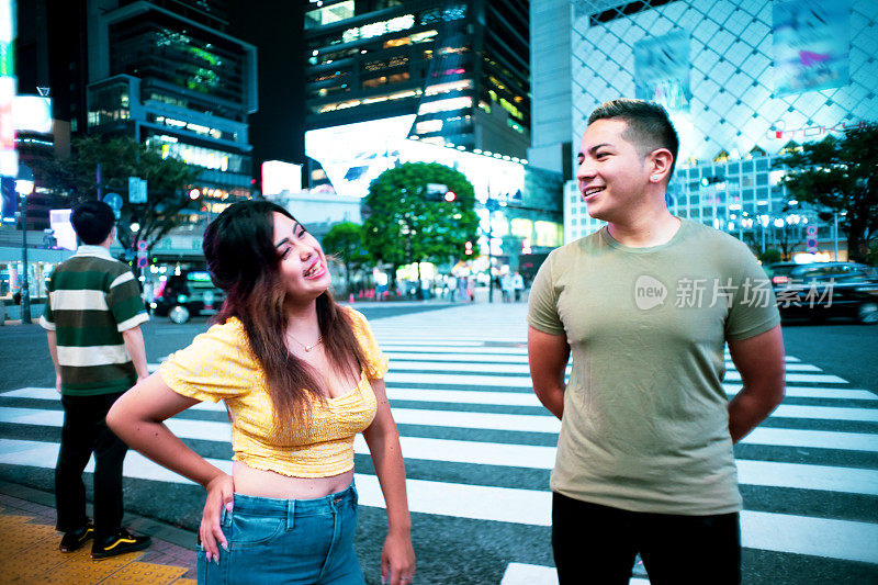 年轻男女晚上在街上聊天的肖像。