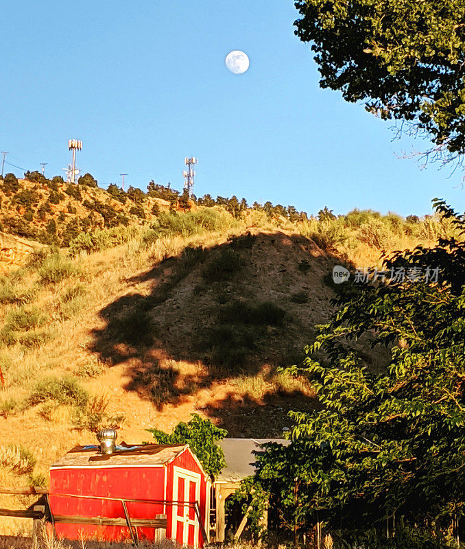 满月升起在南台地，从犹他州罗克维尔和悬崖底部的小红色花园棚看到