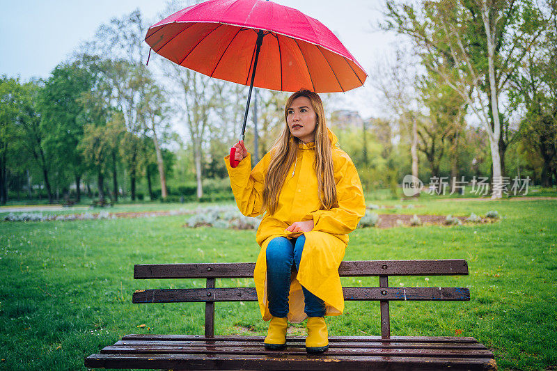 在雨中打着红伞的女人