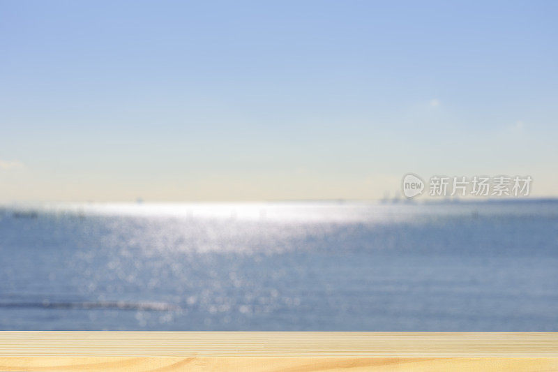 空白的木桌顶，映衬着模糊闪亮的大海