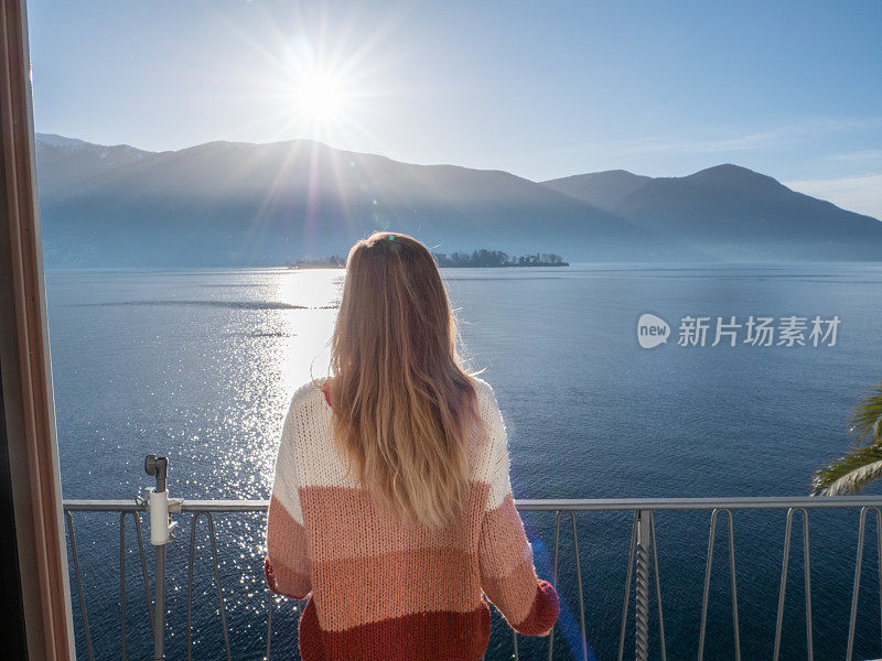 日出时站在阳台上的女人的背影