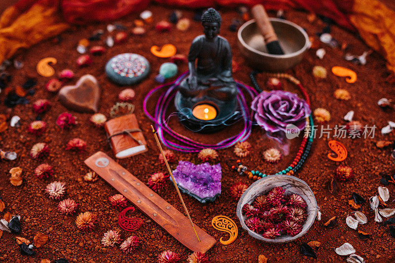 红褐色土壤上的冥想仪式静物，有佛、香和各种精神物品
