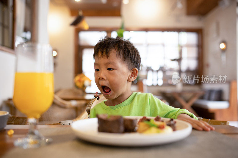 一个亚洲男孩在餐馆吃饭