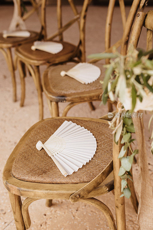 美丽的婚礼椅子与鲜花的安排和白色西班牙手扇子