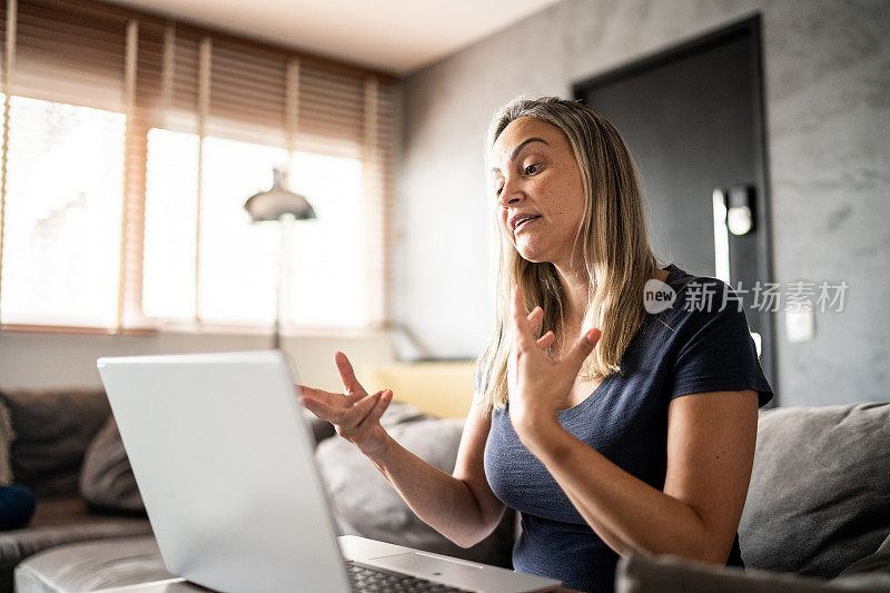 一个成熟的女人在家里打视频电话