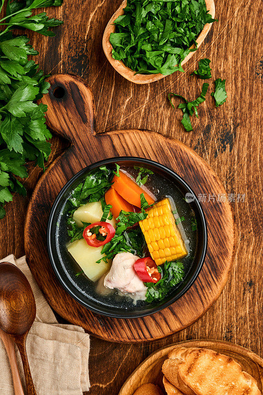 智利肉汤，玉米，新鲜的香菜和土豆放在旧木桌的背景上。做到。Latinamerican食物。