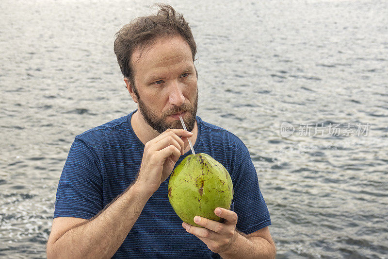 一个人在海边喝椰子水