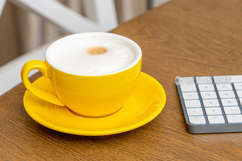 黄色咖啡杯和电脑键盘