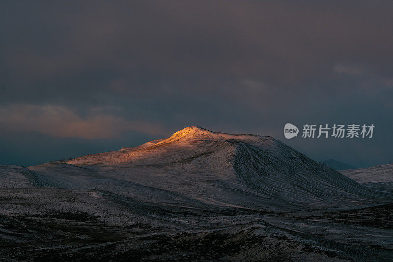 北方的日落。宁静的山景与神奇的粉红色光