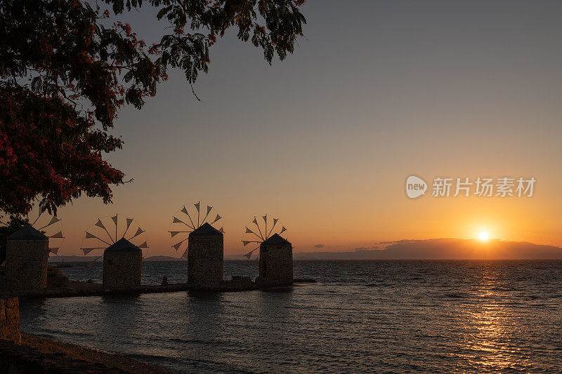 日出时分，希腊希俄斯岛希俄斯镇海滩上的古老传统风车