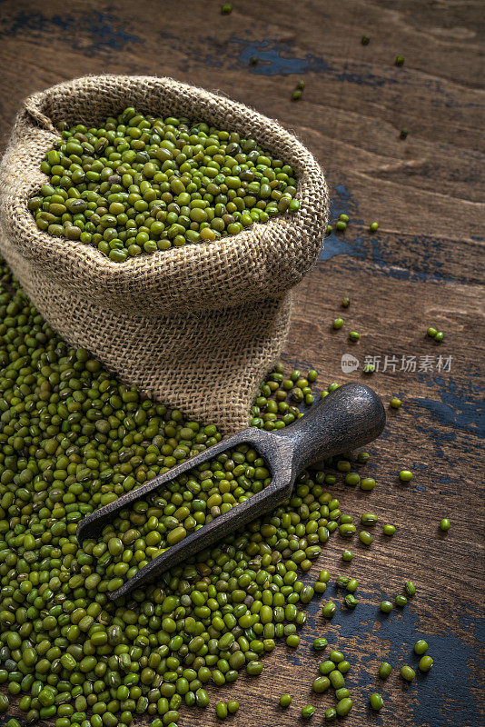 绿色大豆，绿豆干豆荚在一个粗麻袋和木材服务勺在乡村深色木材