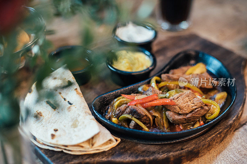 墨西哥牛肉卷配彩色灯笼椒和玉米饼面包和酱汁