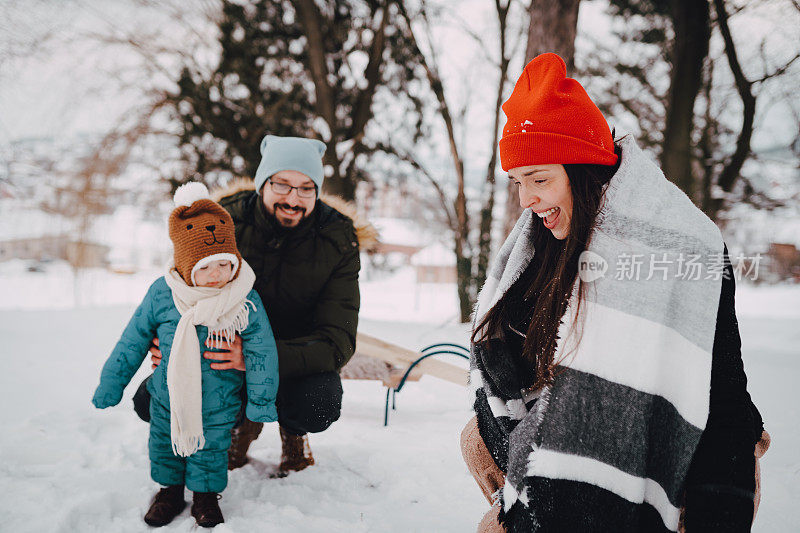 幸福的家庭和孩子在冬天的雪橇上散步