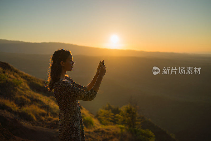 日出时，女徒步旅行者在山脊上休息