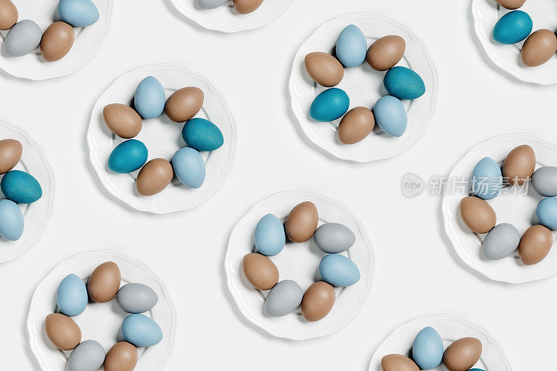 染色复活节蛋柔和的颜色，蓝色，灰色，米色在圆形白色板作为图案。节日理念快乐复活节，庆祝美食，装饰鸡蛋鸡蛋，中性新潮色彩。