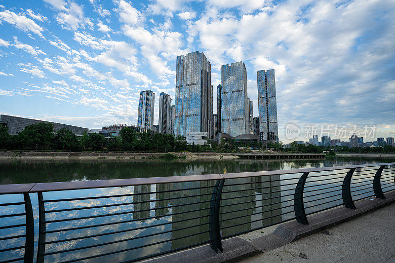 阳光明媚的日子里，沿河有现代化的建筑和桥梁