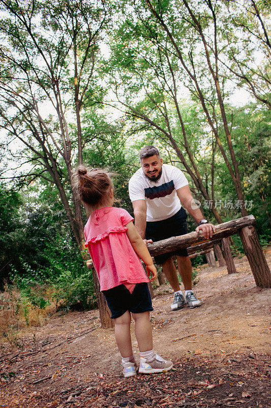 小爸爸和她的小女儿在树林里玩耍的特写镜头