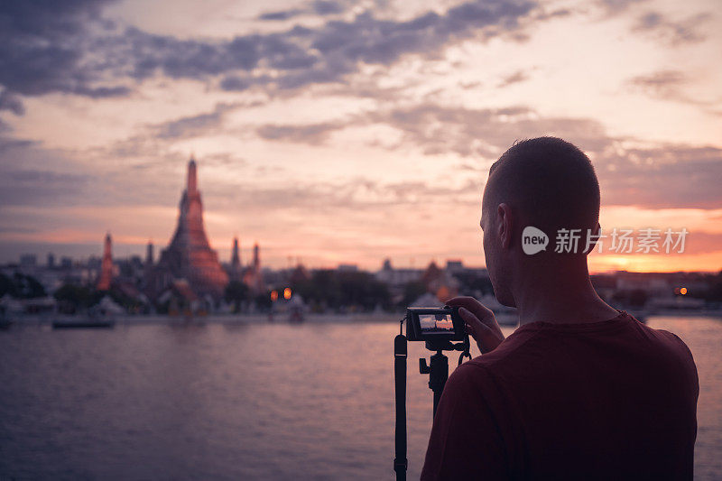 日落时拍摄曼谷城市景观的男子