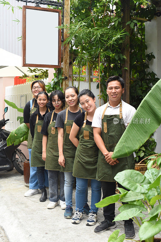 越南咖啡店团队微笑着站在一起对着一家咖啡馆