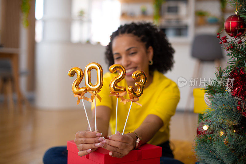 快乐的女人在家里庆祝新年库存照片