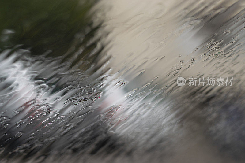雨点打在车窗上，勾勒出汽车的轮廓